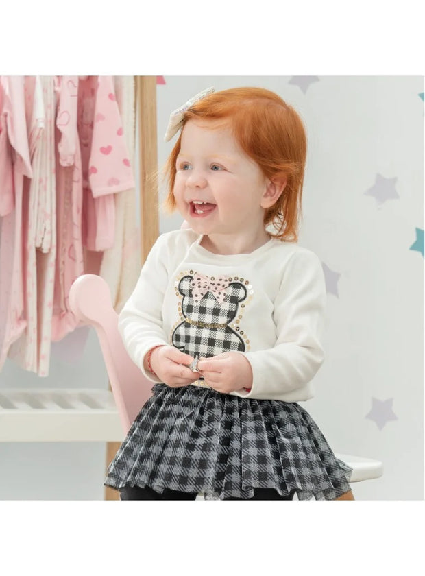 Σετ βρεφικών ρούχων για κορίτσι που περιλαμβάνει λευκή μπλούζα με σχέδιο καρό αρκουδάκι και διακοσμητικό φιόγκο, και μαύρο κολάν με ενσωματωμένη καρό φούστα. Κομψό και παιχνιδιάρικο για ιδιαίτερες εμφανίσεις