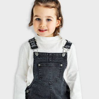 Κοριτσάκι φοράει παιδικό σετ Energiers με μαύρη τζιν σαλοπέτα και λευκό ζιβάγκο.