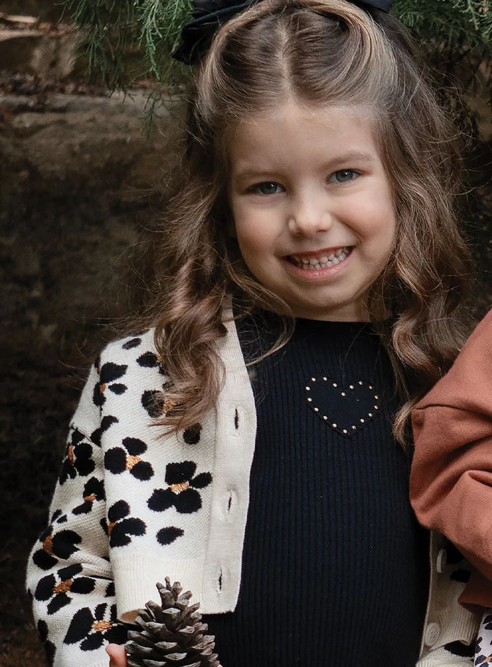 Κοριτσάκι φοράει παιδική μπλούζα Energiers ριμπ μαύρη με καρδιά και τρουκ.