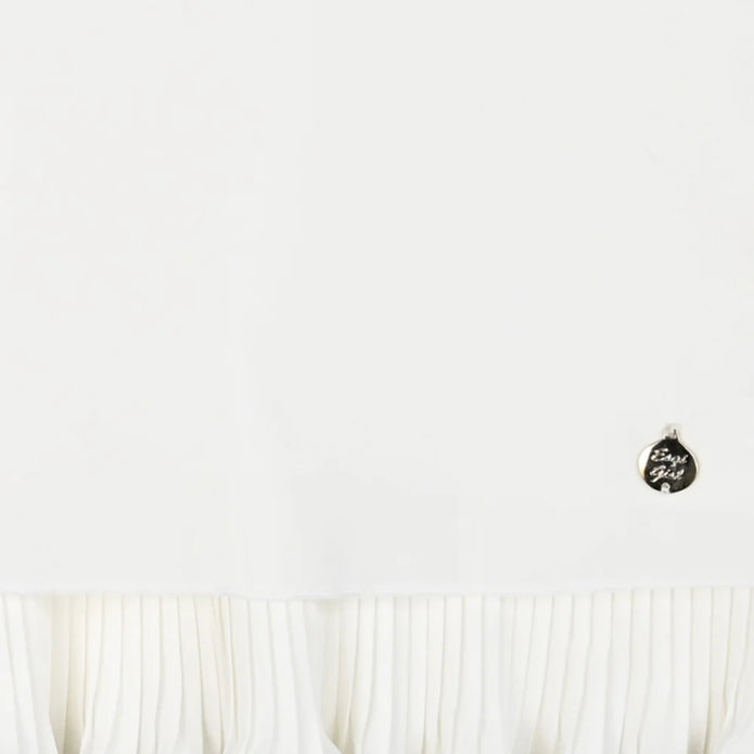 Μπλούζα για κορίτσια σε λευκό χρώμα με μακριά μανίκια και λεπτομέρεια πιέτας στο κάτω μέρος. Διαθέτει διακριτικό μεταλλικό διακοσμητικό στη γωνία, προσφέροντας κομψότητα και στυλ. πουκαμίσα για κορίτσι 