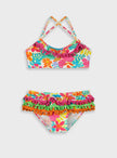 Crop top του παιδικού μαγιό μπικίνι Swimmy με πομ πομ και τροπικό μοτίβο

Πίσω όψη του σετ μαγιό μπικίνι Swimmy με χιαστί τιράντες και floral σλιπ

Παιδικό μαγιό μπικίνι Swimmy με πομ πομ και έντονα χρώματα

Κορίτσι φοράει το παιδικό μαγιό μπικίνι Swimmy στην παραλία