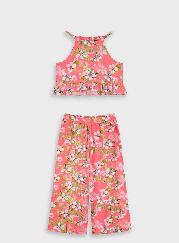 "Παιδικό σετ κοριτσιού με φλοράλ τοπ και παντελόνα σε ροζ φόντο – flat lay παρουσίαση"