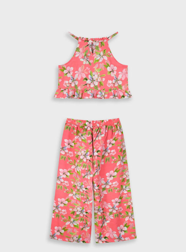 "Παιδικό σετ κοριτσιού με φλοράλ τοπ και παντελόνα σε ροζ φόντο – flat lay παρουσίαση"
